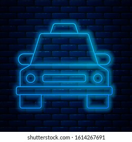 Glowing neon line Taxi car icon isolated on brick wall background.  Vector Illustration
