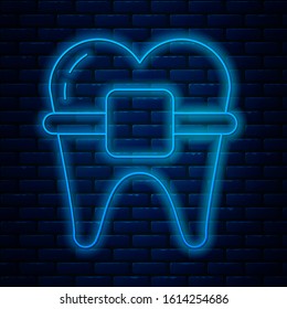Glowing neon line Teeth with braces icon isolated on brick wall background. Alignment of bite of teeth, dental row with with braces. Dental concept.  Vector Illustration