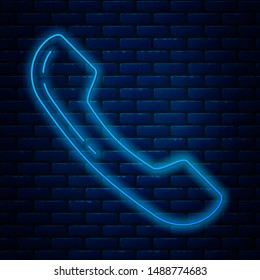 Glowing neon line Telephone handset icon isolated on brick wall background. Phone sign.  Vector Illustration