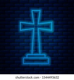 Glowing neon line Tombstone with cross icon isolated on brick wall background. Grave icon.  Vector Illustration