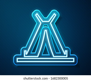 Glowing neon line Traditional indian teepee or wigwam icon isolated on blue background. Indian tent.  Vector Illustration