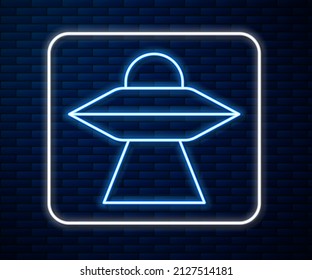 Glowing neon line UFO flying spaceship icon isolated on brick wall background. Flying saucer. Alien space ship. Futuristic unknown flying object.  Vector