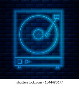 Glowing neon line Vinyl player with a vinyl disk icon isolated on brick wall background.  Vector Illustration