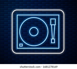 Glowing neon line Vinyl player with a vinyl disk icon isolated on brick wall background.  Vector Illustration