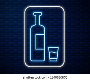 Glowing neon line Whiskey bottle and glass icon isolated on brick wall background.  Vector Illustration