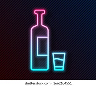 Glowing neon line Whiskey bottle and glass icon isolated on black background.  Vector Illustration