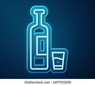 Glowing neon line Whiskey bottle and glass icon isolated on blue background.  Vector Illustration