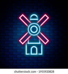 Glowing neon line Windmill icon isolated on brick wall background. Colorful outline concept. Vector
