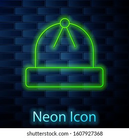 Glowing neon line Winter hat icon isolated on brick wall background.  Vector Illustration
