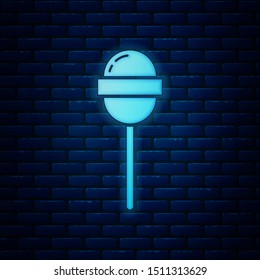 Glowing neon Lollipop icon isolated on brick wall background. Food, delicious symbol.  Vector Illustration