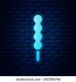 Glowing neon Lollipop icon isolated on brick wall background. Candy sign. Food, delicious symbol.  Vector