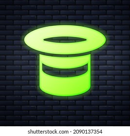 Glowing neon Magic hat icon isolated on brick wall background. Magic trick. Mystery entertainment concept.  Vector