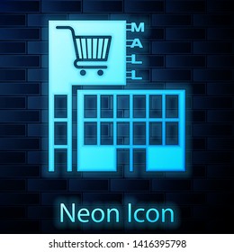 Glowing neon Mall or supermarket building with shopping cart icon isolated on brick wall background. Shop or store.  Vector Illustration