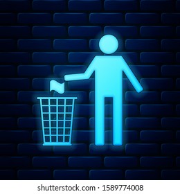 Glowing neon Man throwing trash into dust bin icon isolated on brick wall background. Recycle symbol.  Vector Illustration