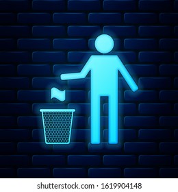 Glowing neon Man throwing trash into dust bin icon isolated on brick wall background. Recycle symbol. Trash can sign.  Vector Illustration