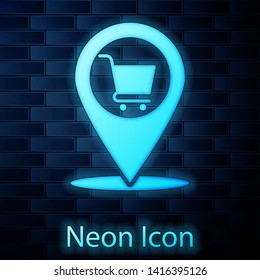 Glowing neon Map pointer with shopping cart icon isolated on brick wall background. Pin point shop and shopping. Supermarket basket symbol. Vector Illustration