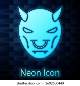 Glowing neon Mask of the devil with horns icon isolated on brick wall background.  Vector Illustration