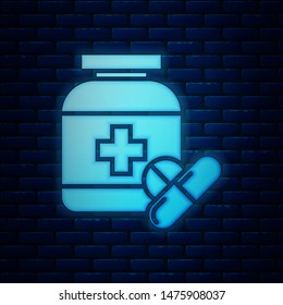 Glowing neon Medicine bottle and pills icon isolated on brick wall background. Bottle pill sign. Pharmacy design.  Vector Illustration