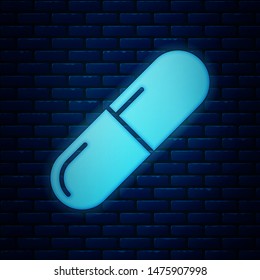 Glowing neon Medicine pill or tablet icon isolated on brick wall background. Capsule pill and drug sign. Pharmacy design.  Vector Illustration