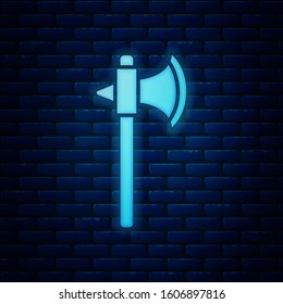 Glowing neon Medieval axe icon isolated on brick wall background. Battle axe, executioner axe.  Vector Illustration