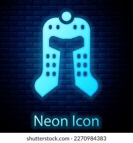 Glowing neon Medieval iron helmet for head protection icon isolated on brick wall background.  Vector