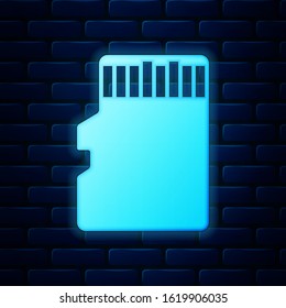 Glowing neon Micro SD memory card icon isolated on brick wall background.  Vector Illustration