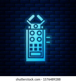 Glowing neon Microphone icon isolated on brick wall background. On air radio mic microphone. Speaker sign.  Vector Illustration