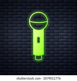Glowing neon Microphone icon isolated on brick wall background. On air radio mic microphone. Speaker sign.  Vector