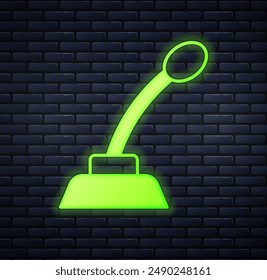 Glowing neon Microphone icon isolated on brick wall background. On air radio mic microphone. Speaker sign.  Vector