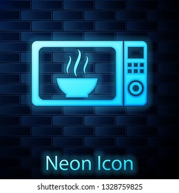 Glowing neon Microwave oven icon isolated on brick wall background. Home appliances icon.Vector Illustration
