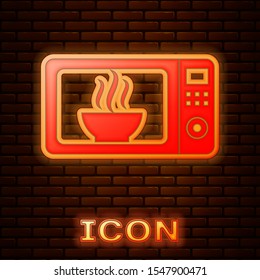 Glowing neon Microwave oven icon isolated on brick wall background. Home appliances icon.  Vector Illustration
