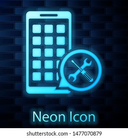 Glowing neon Mobile Apps with screwdriver and wrench icon isolated on brick wall background. Adjusting, service, setting, maintenance, repair, fixing.  Vector Illustration