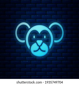 Glowing neon Monkey icon isolated on brick wall background. Animal symbol.  Vector