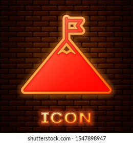Glowing neon Mountains and flag on top icon isolated on brick wall background. Symbol of victory or success concept.  Vector Illustration