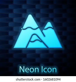 Glowing neon Mountains icon isolated on brick wall background. Symbol of victory or success concept.  Vector Illustration