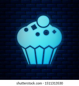 Glowing neon Muffin icon isolated on brick wall background.  Vector Illustration