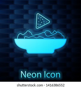 Glowing neon Nachos in plate icon isolated on brick wall background. Tortilla chips or nachos tortillas. Traditional mexican fast food. Vector Illustration