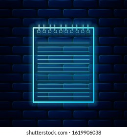 Glowing neon Notebook icon isolated on brick wall background. Spiral notepad icon. School notebook. Writing pad. Diary for business. Notebook cover design.  Vector Illustration