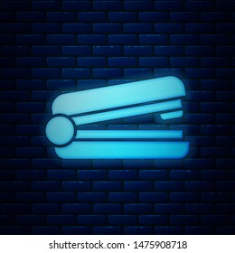 Glowing neon Office stapler icon isolated on brick wall background. Stapler, staple, paper, cardboard, office equipment.  Vector Illustration