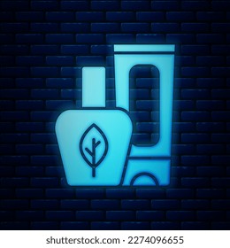 Glowing neon Ointment cream tube medicine icon isolated on brick wall background. Tube, container, toothpaste, cream sign.  Vector