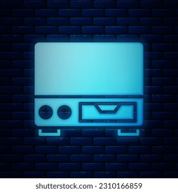 Glowing neon Old video cassette player icon isolated on brick wall background. Old beautiful retro hipster video cassette recorder.  Vector