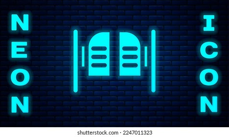 Glowing neon Old western swinging saloon door icon isolated on brick wall background.  Vector Illustration