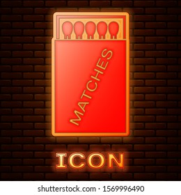 Glowing neon Open matchbox and matches icon isolated on brick wall background.  Vector Illustration
