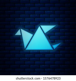 Glowing neon Origami bird icon isolated on brick wall background.  Vector Illustration