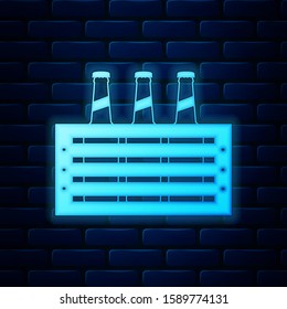 Glowing neon Pack of beer bottles icon isolated on brick wall background. Wooden box and beer bottles. Case crate beer box sign.  Vector Illustration