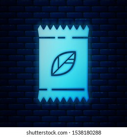 Glowing neon A pack full of seeds of a specific plant icon isolated on brick wall background.  Vector Illustration