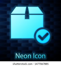Glowing neon Package box with check mark icon isolated on brick wall background. Parcel box with checkmark. Approved delivery or successful package receipt.  Vector Illustration