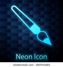 Glowing neon Paint brush icon isolated on brick wall background. Vector.
