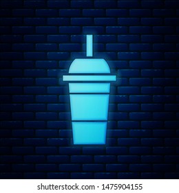 Glowing neon Paper glass with drinking straw and water icon isolated on brick wall background. Soda drink glass. Fresh cold beverage symbol.  Vector Illustration