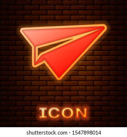 Glowing neon Paper plane icon isolated on brick wall background. Paper airplane icon. Aircraft sign.  Vector Illustration